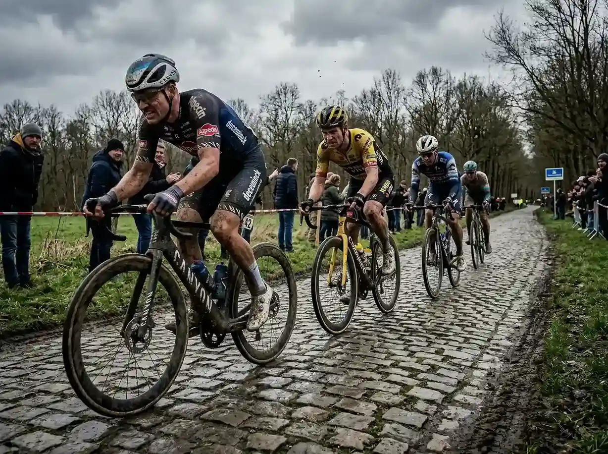 Cyclistes professionnels sur les pavés légendaires de Paris-Roubaix couverts de boue sous un ciel gris
